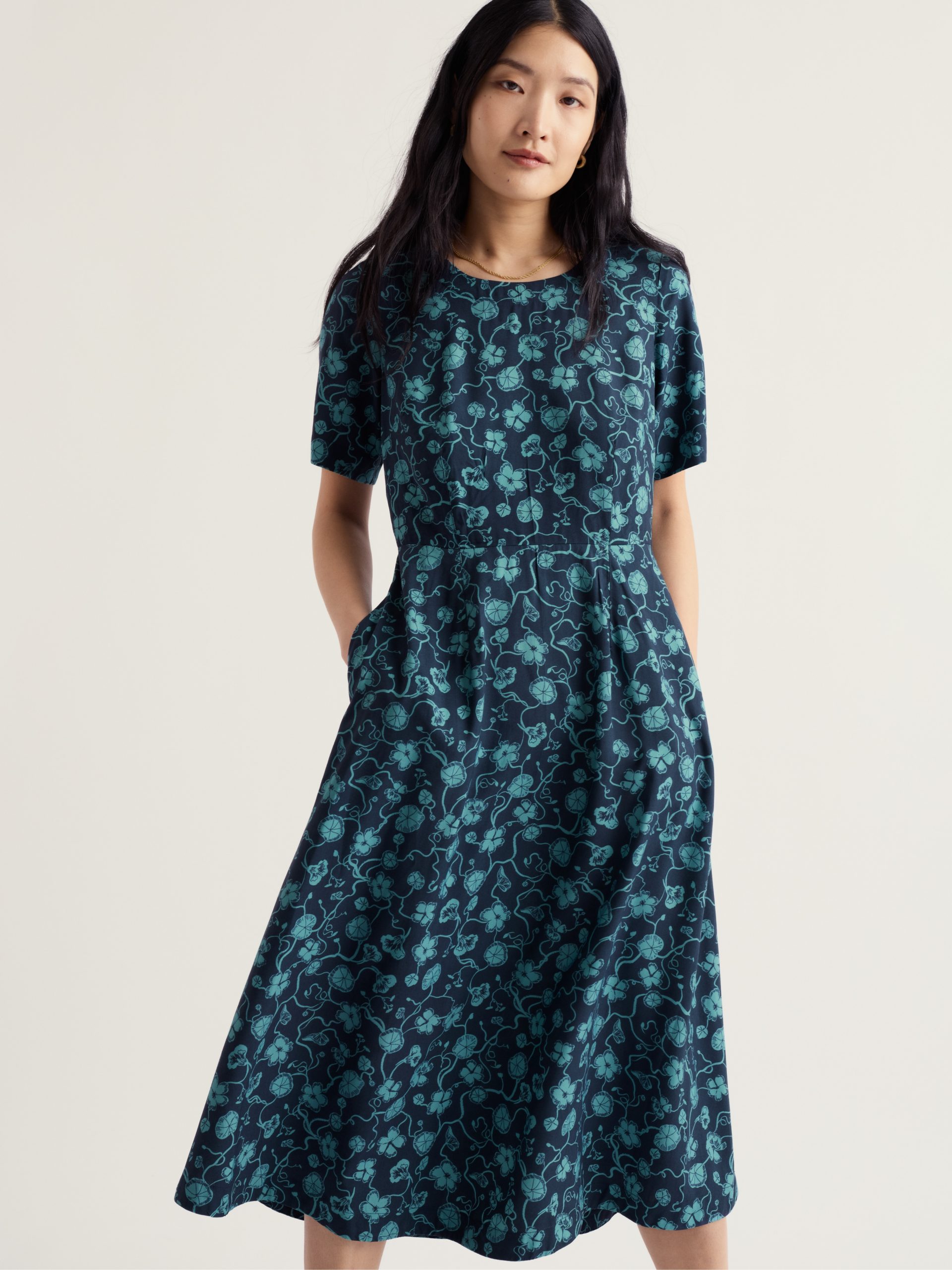 Seasalt Tilly jurk Nasturtium Press Eucalyptus in donkerblauw met eucalyptusgroene botanische print, korte mouwen en zwierige midirok.